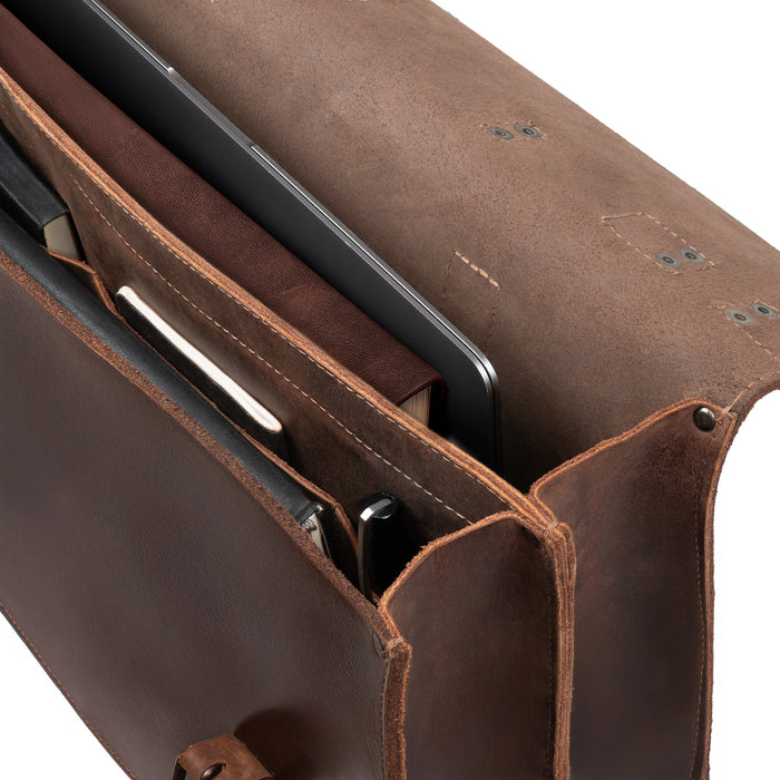 Close-up of the Hide & Drink 2-Compartment Thick Messenger Bag, highlighting its interior with dedicated compartments for laptops and accessories. This Rustic Briefcase with Adjustable Shoulder Strap is a Heavy Duty Satchel, perfect for travel. Made from Full Grain Leather, this Handmade accessory emphasizes Artisan quality from small batch production in La Antigua Guatemala & Oaxaca Mexico.