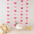 Butterfly decoration backdrop with cake and cupcakes at a celebration.