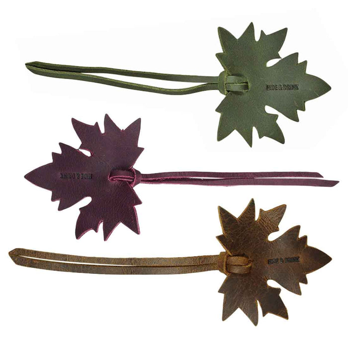 A detailed view of the Autumn Bookmark (3 pack) by Hide & Drink, featuring a set of three leather bookmarks, each shaped like a maple leaf. These handcrafted bookmarks are great for book lovers and perfect as gifts, exemplifying the quality of full grain leather. Autumn Bookmark (3 Pack), Bookworm Gifts, Cute Accessories, Small Batch Production, Hand Cut, Hand Sewn.