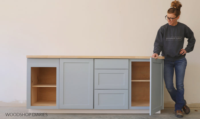 Builder standing next to finished DIY base cabinets in a laundry room