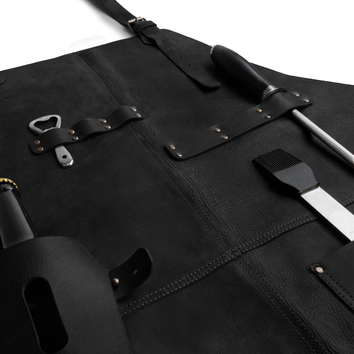 Measurement view of Cast Leather Co. BBQ Apron in black, presenting dimensions while highlighting its rustic chef design with adjustable neck strap. This artisan piece is made from full grain leather, ensuring quality and style for any cooking enthusiast.