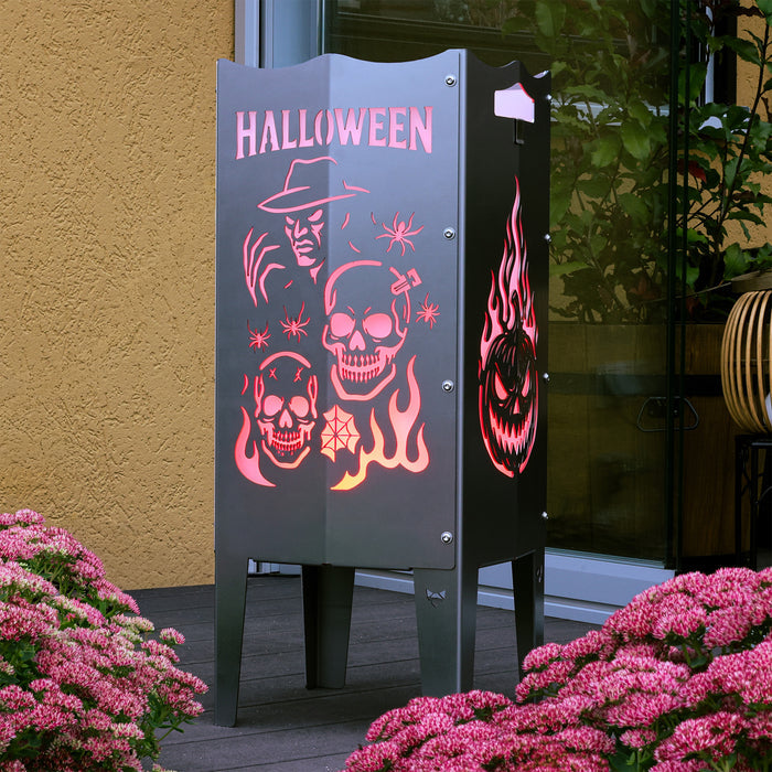 Die FENNEK Feuersäule aus Edelstahl mit Halloween Motiv steht auf einer Terrasse. Die Feuersäule leuchtet dank des LED Lichtersets rot. So schafft sie auch ganz ohne Feuer eine tolle Atmosphäre.