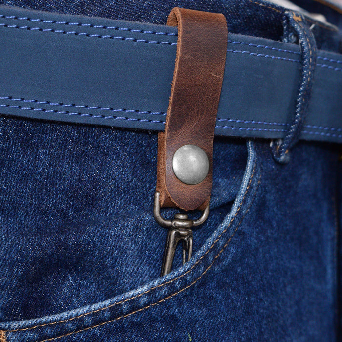 Belt Key Holder by Hide & Drink worn on a belt, showcasing its practical design and rustic charm. Dimensions Length: 4.25 in. Height: 1 in. Width: 0.50 in. Crafted from Full Grain Leather, it ages beautifully and can be protected with mineral oil or beeswax leather conditioner.