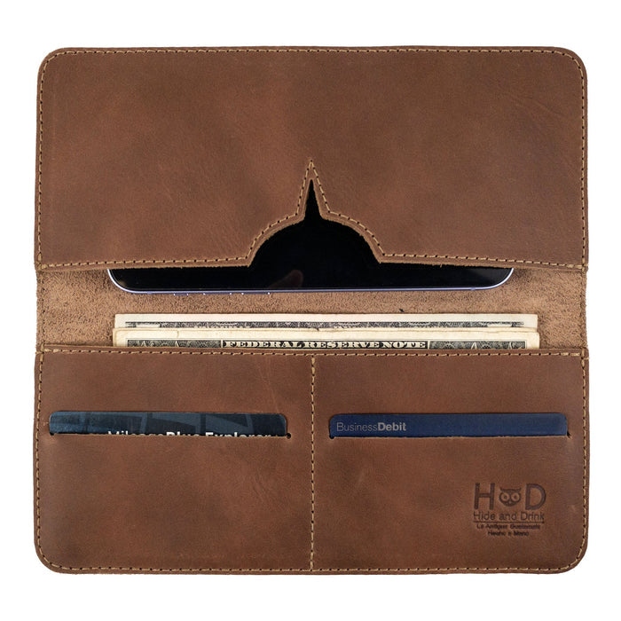 Closed view of the rustic bifold wallet for cellphone by Hide & Drink, focusing on its durable leather. This Bifold Wallet for Cellphone is a stylish accessory made from Full Grain Leather, perfect for daily essentials. Enjoy the artisan craftsmanship in this piece, made through small batch production in La Antigua Guatemala & Oaxaca Mexico.