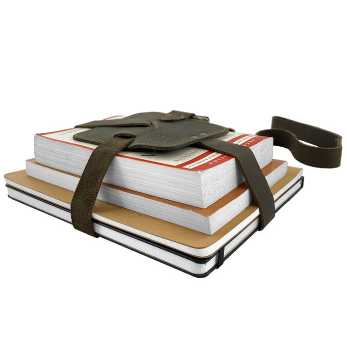 Hide & Drink Book Strap Carrier used with notebooks, showcasing its ergonomic design. This Full Grain Leather accessory is artisan-crafted in La Antigua Guatemala and is perfect for readers on the go.