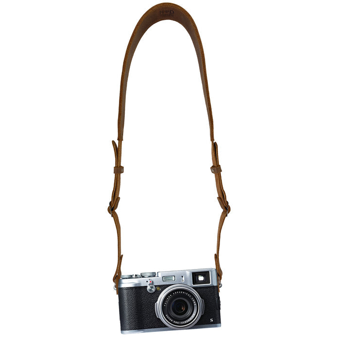Hide & Drink Rustic Camera Strap modeled with a camera, illustrating its stylish and functional design. Handmade from Full Grain Leather, it's adjustable and perfect for mirrorless and compact cameras—an excellent gift for photographers. StockyardX, Small Batch Production, Hand Cut, Hand Sewn, Fire Branded, Artisan, Handmade in La Antigua Guatemala & Oaxaca Mexico.