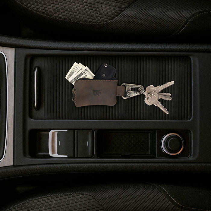 Hide & Drink Car Key Holder placed inside a car's console, demonstrating its functionality in holding keys, cash, and cables. This handmade leather accessory is perfect for keeping essentials organized.