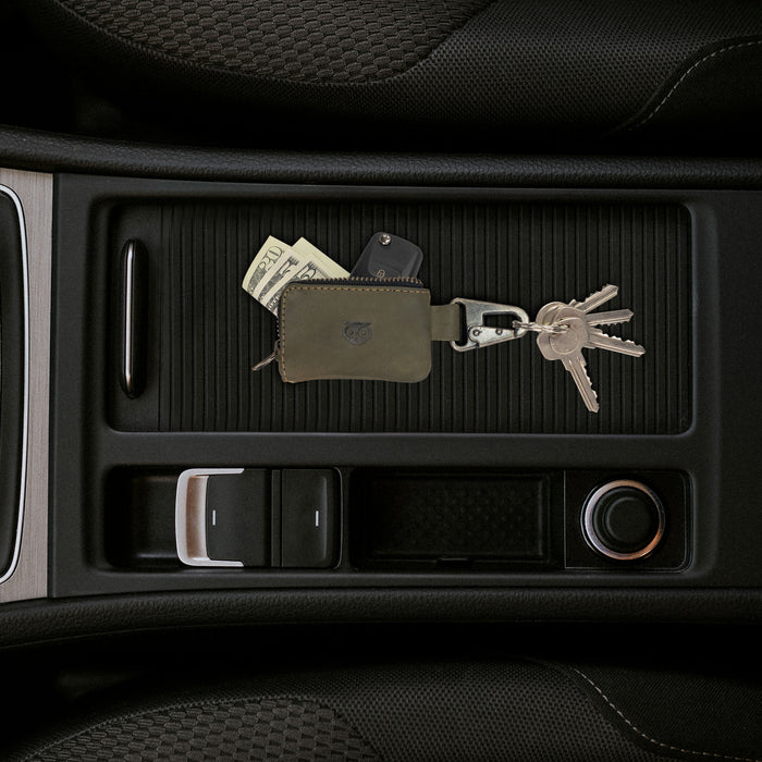 Hide & Drink Car Key Holder displayed in olive green leather, showcasing its design for keys and cash while serving as a storage for charging cables and accessories, secured with a Nickel Metal Clasp. StockyardX, Small Batch Production, Hand Cut, Hand Sewn, Fire Branded, Artisan, Handmade in La Antigua Guatemala & Oaxaca Mexico.