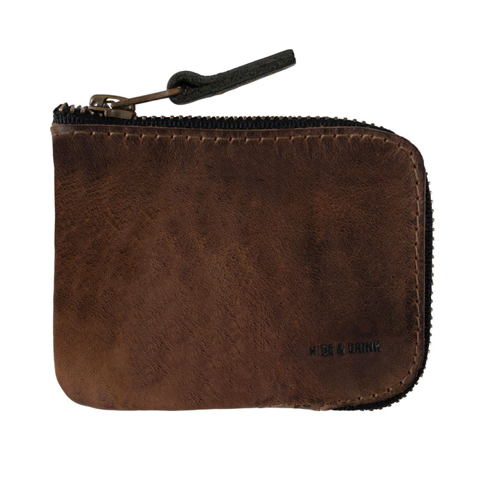 A stylish Card Pocket Wallet by Hide & Drink, featuring a compact design in full grain leather. This zippered card wallet for men and women serves as a coin pouch and money holder while keeping everything organized. Handmade in La Antigua Guatemala, it showcases small batch production, hand cut and hand sewn craftsmanship, with fire branded details.