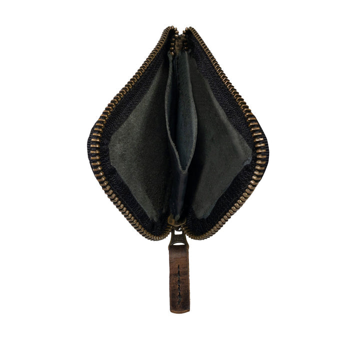 A side view of a black Hide & Drink Card Pocket Wallet emphasizing its durability. This zippered card wallet for men and women serves as a coin pouch and money holder, made from full grain leather, showcasing artisan craftsmanship from La Antigua Guatemala.