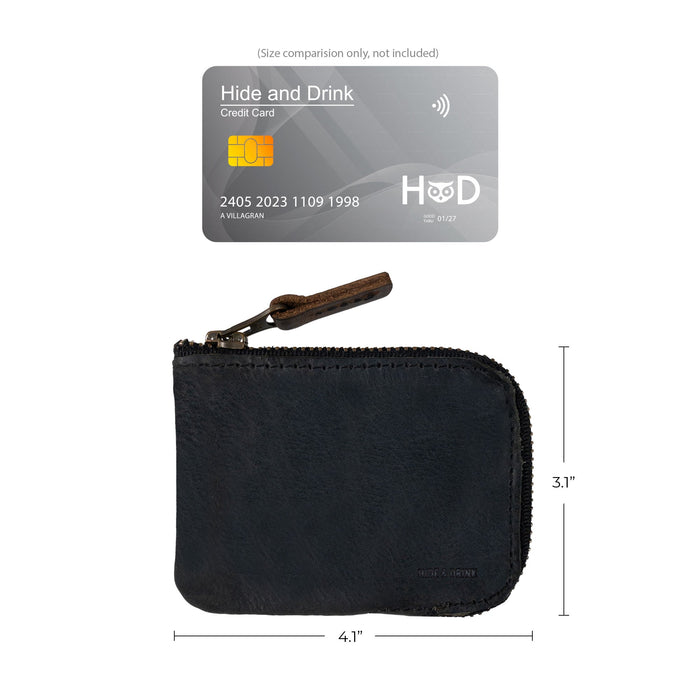 The size comparison of a Hide & Drink Card Pocket Wallet in sleek black leather. This zippered card wallet for men and women serves as a coin pouch and money holder, crafted from full grain leather and highlighting the small batch artisan production from La Antigua Guatemala.