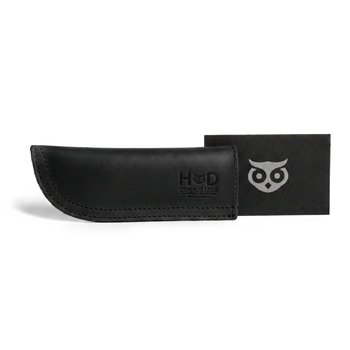 Hide & Drink Cast Iron Panhandle Cover elegantly presented on a skillet, exemplifying its craftsmanship. This durable hot handle protector is made from full grain leather with double stitching for enhanced durability. Handmade in La Antigua Guatemala & Oaxaca Mexico, it's perfect for every cooking enthusiast.