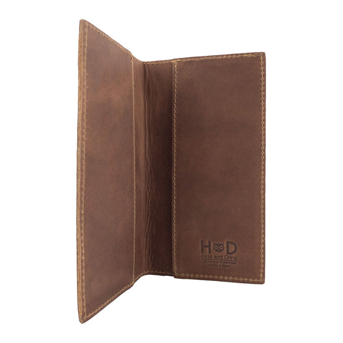 Opened view of the brown Checkbook Leather Cover by Hide & Drink, ideal as a minimalist organizer for standard checkbooks. Made from full grain leather, this handmade piece showcases artisan craftsmanship from La Antigua Guatemala and Oaxaca Mexico, reflecting small batch production.