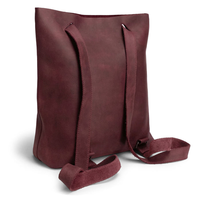 Heather's Convertible Backpack to Shoulder Bag viewed from the back, displaying its versatility and chic maroon color. This spacious crossbody for women is crafted from Full Grain Leather, highlighting the quality of small batch production and the artisan skills involved, including hand cut and hand sewn details. Handmade in La Antigua Guatemala & Oaxaca Mexico.