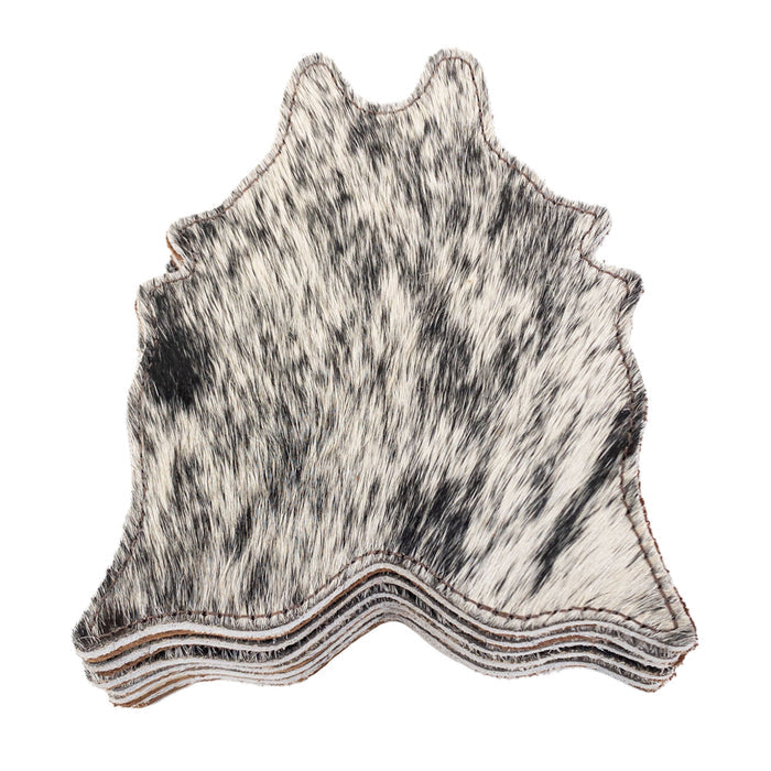 Stacked view of Cowhide Shape Set of 6 Coasters from Western Leather Works featuring a black and white design. Made from Hair On Hide Full Grain Leather, these coasters are handcrafted in La Antigua Guatemala & Oaxaca Mexico, perfect for drinks and showcasing small batch production.