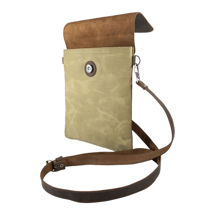 Hide & Drink Crossbody Bag displayed in a closed position, showcasing its sleek design and button closure. This Crossbody Bag with Adjustable Shoulder Strap is a Unisex Messenger Bag made from durable Full Grain Leather & Waxed Canvas, highlighting small batch production, hand cut, hand sewn, fire branded style, crafted by artisans in La Antigua Guatemala & Oaxaca Mexico.