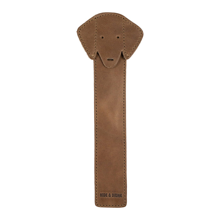 The front view of Hide & Drink's tan Dog Bookmark made from Full Grain Leather, showcasing a cute dog face design. This handmade bookmark exemplifies craftmanship from small batch production and fire branding, made in La Antigua Guatemala & Oaxaca Mexico.