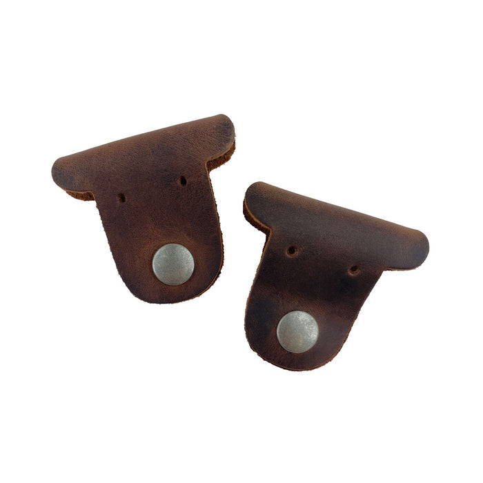 Another angle of two dark brown Dog Shaped Cord Keepers, made from Full Grain Leather, by Hide & Drink, designed for stylish cord management. Dog Shaped Cord Keeper (Cord Clam) 2-Pack, Full Grain Leather, StockyardX, Small Batch Production, Hand Cut, Hand Sewn, Fire Branded, Artisan, Handmade in La Antigua Guatemala & Oaxaca Mexico.