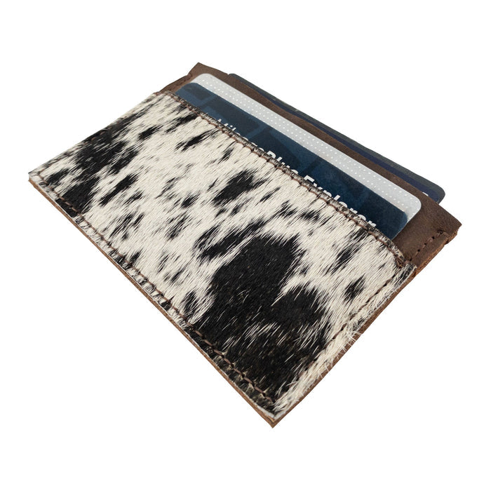 Top view of the Western Leather Works Double Card Wallet filled with cards. This handcrafted product is a perfect example of compact storage, functioning well as an ID holder or travel accessory. Made with care in La Antigua Guatemala using hair-on-hide full grain leather, emphasizing artisan craftsmanship.