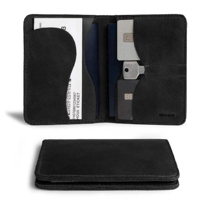 Black version of Hide & Drink's Double Passport Wallet W/Key Slot displaying slots for cards and bills, expertly crafted in a rustic full grain leather, ideal as a travel accessory for organized journeys.
