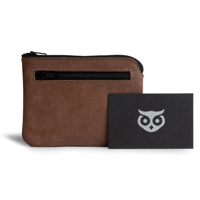 The Double Wallet Coin Pouch by Hide & Drink is shown alongside its branding card, emphasizing its Full Grain Leather design. A perfect blend of style and functionality, it highlights artisan methods including small batch production, hand cut and hand sewn techniques, and a fire branded process, handmade in La Antigua Guatemala & Oaxaca Mexico.