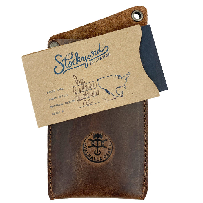 Valhalla Gear EDC Knife Sheath accompanied by a card showcasing its artisan quality. Made from full grain leather, this rectangular knife sheath is an ideal vertical holster for multitools and a practical tool case for camping and outdoor accessories. Hand cut and hand sewn in La Antigua Guatemala, fire branded for authenticity.