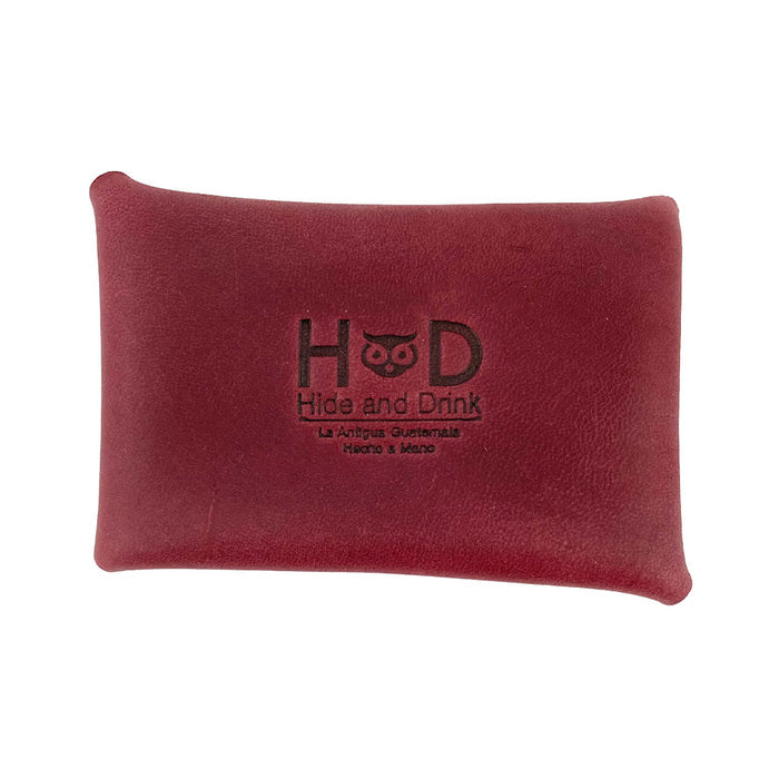 The burgundy Hide & Drink Envelope Coin Case featuring a branded logo, emphasizing quality craftsmanship. Handcrafted from full grain leather, this rustic leather case is made in La Antigua Guatemala & Oaxaca Mexico.