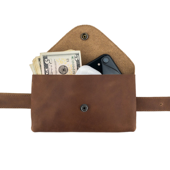 Cash and smartphone stored inside Hide & Drink's Fancy Fanny Pack, highlighting its utility and modern design. Made from full grain leather, this artisan-made fanny pack is perfect as a phone holder, showcasing craftsmanship from La Antigua Guatemala.