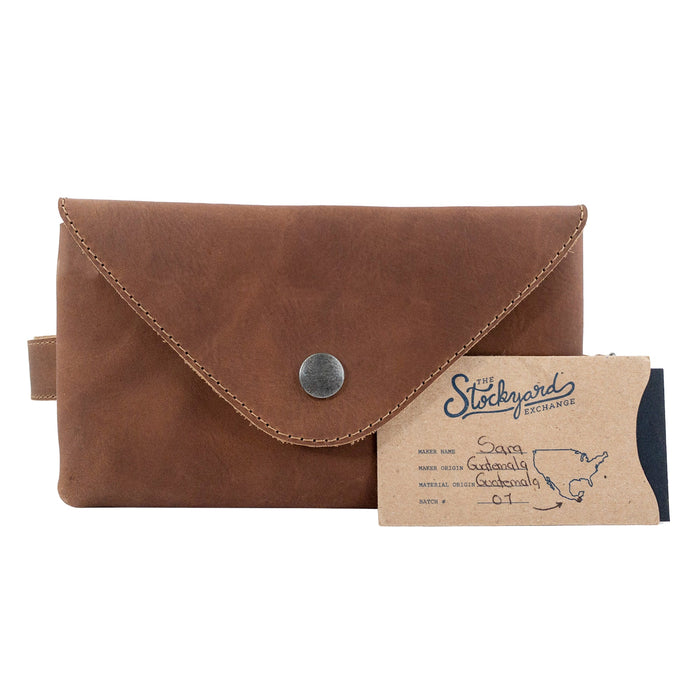 Hide & Drink's Fancy Fanny Pack in rich brown, featured with brand tags, exemplifying quality and craftsmanship. Made from full grain leather, this artisan waist pouch is great for travel and serves as a vintage purse.