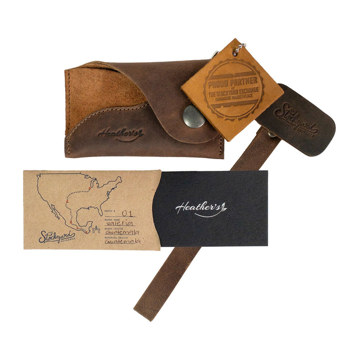 The Heather's Female Wallet with Wristlet unboxed, highlighting its craftsmanship including the ID case with wrist strap. This full grain leather wallet is perfect for organizing money and essentials, handmade in La Antigua Guatemala and Oaxaca Mexico with artisanal care.