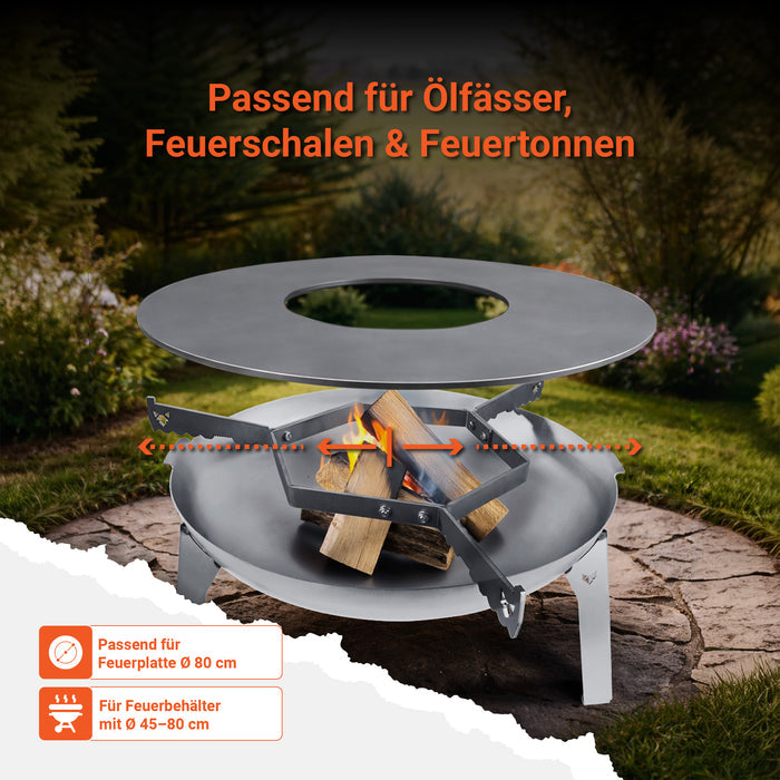 Die FENNEK Feuerschale 3Pod aus Edelstahl steht in einem schönen Garten. Auf dem Rand der Feuerschale liegt die FENNEK Auflageleiste auf, welche passend für Feuerschalen, Ölfässer und Feuertonnen ist. Sie ist passend für Feuerplatten mit 80 cm Durchmesser
