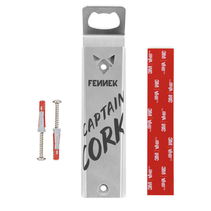 Freisteller vom FENNEK Faschenöffner Captain Cork - Magnet vor weißem Hintergrund. Eingraviert ist der Schriftzug Captain Cork und FENNEK. Das FENNEK-Logo ist aus dem Edelstahl geschnitten. Links daneben sind 2 Schrauben inkl. Dübel sowie rechts daneben ein Klebestreifen zur Befestigung abgebildet.