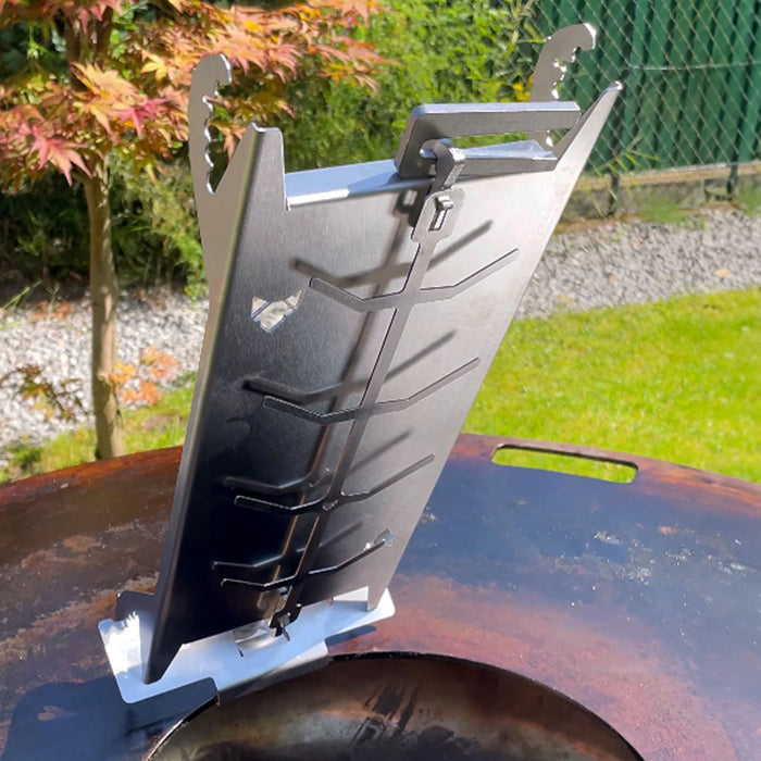 Der FENNEK Edelstahl Flammlachshalter Shorty ist auf dem Feuerplatten Adapter für Feuerplatten gesteckt welcher auf der Feuerplatte montiert ist.