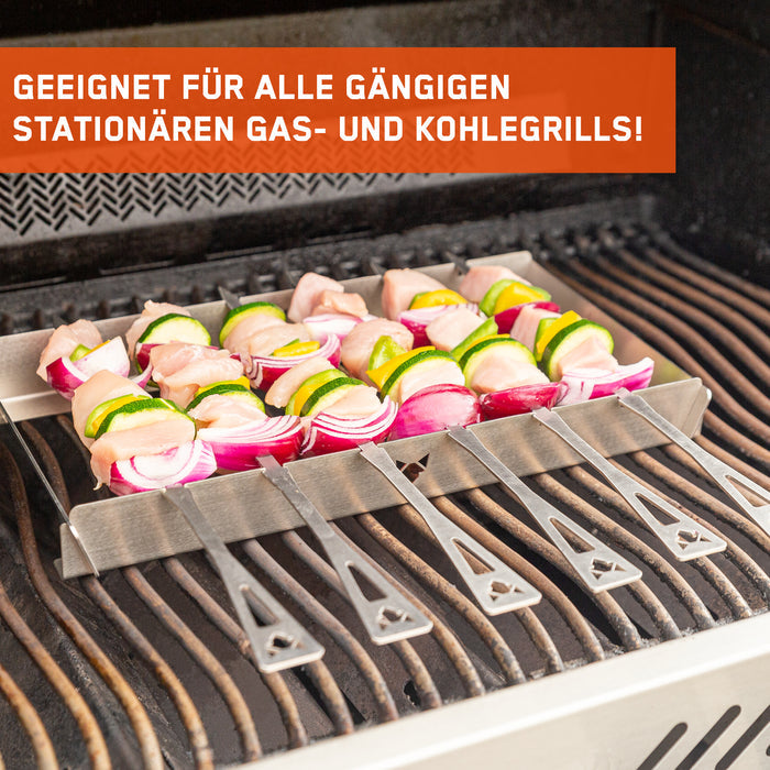 Auf einem Gasgrill grillen sechs Hähnchen-Gemüse Spieße, die auf der FENNEK Universal Grillspießhalterung liegen.