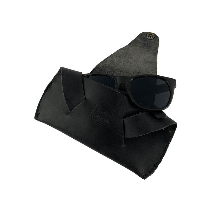 Foldable Sunglass Case by Hide & Drink with sunglasses stored inside, combining style with protection. This case is made from Full Grain Leather, and is a prime example of artisan craftsmanship, featuring hand cut and sewn methods.