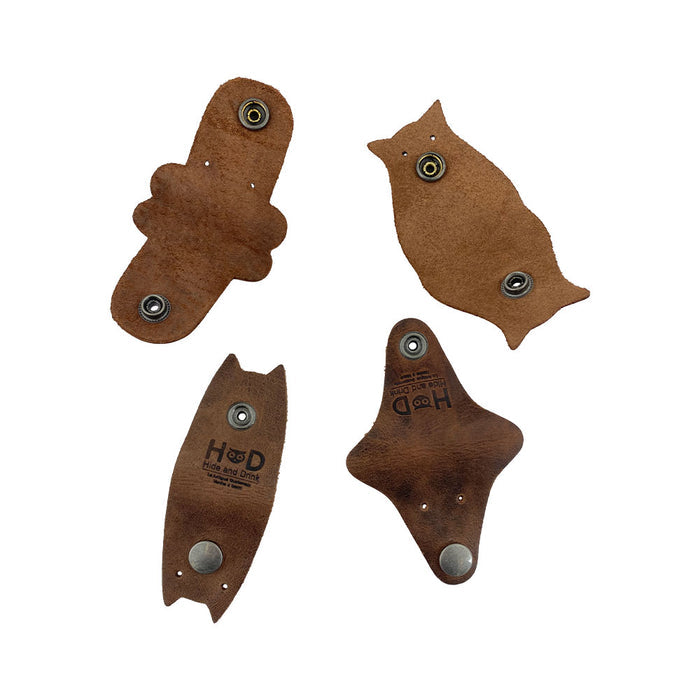 Furry Friends Cord Keeper (4-Pack) featuring unique animal designs, crafted from full grain leather by Hide & Drink to keep your cords neat and tidy. Furry Friends 4-Pack Cord Keeper (Cord Clam), Full Grain Leather, StockyardX, Small Batch Production, Hand Cut, Hand Sewn, Fire Branded, Artisan, Handmade in La Antigua Guatemala & Oaxaca Mexico.