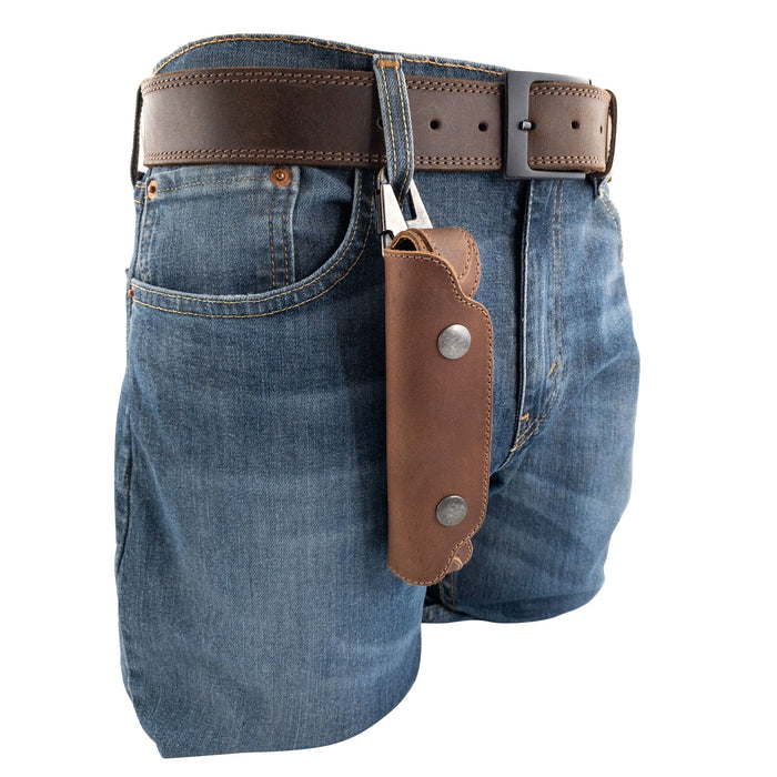 Harmonica Case from Hide & Drink hanging from a belt, emphasizing convenience for musicians on the go. Crafted from durable full grain leather, this vintage style protector ensures both style and functionality.