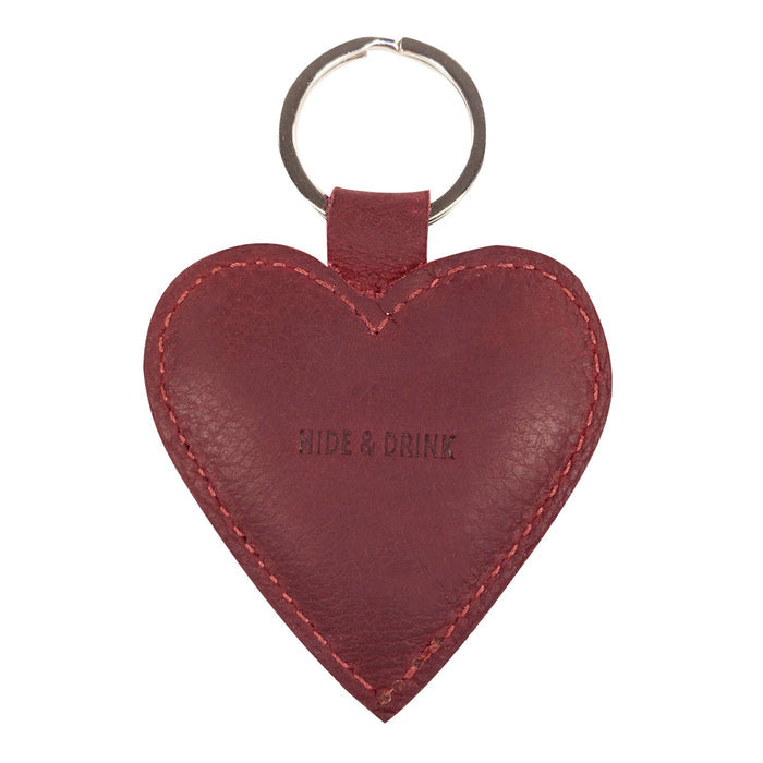 The back view of the Heart Keychain by Hide & Drink, featuring the brand name elegantly embossed on the leather. This lovely heart-shape keychain is perfect for anyone looking for a charming key organizer. Hand cut and hand sewn, this artisan piece is produced in La Antigua Guatemala & Oaxaca Mexico, highlighting its uniqueness.