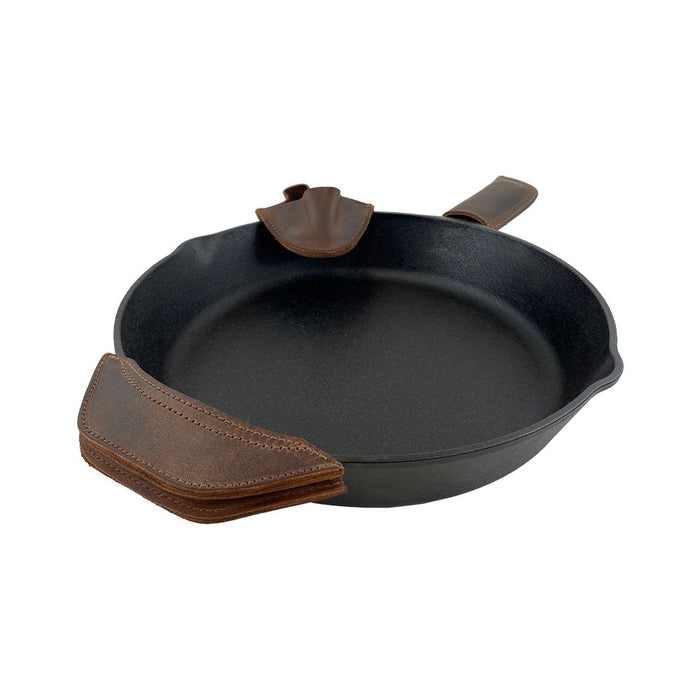 A close-up view of the stunning 3 Rustic Hot Handle Holders by Hide & Drink, demonstrating the craftsmanship in the Panhandle, Side Kick, and Grip Mitt. Perfect for handling hot cast iron skillets, this set is made from Full Grain Leather with attention to Small Batch Production, featuring items that are Hand Cut and Hand Sewn by artisans in La Antigua Guatemala & Oaxaca Mexico.
