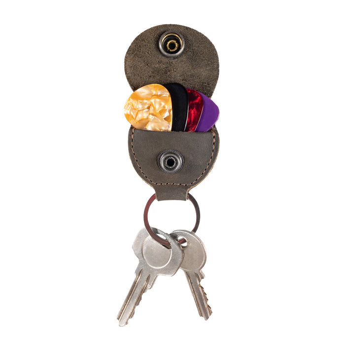 Key Chain & Guitar Pick Holder by Hide & Drink featuring a stylish design with a secure snap closure, perfect for guitar players. This Guitar Pick Holder with Ring serves as a key organizer and is crafted from Full Grain Leather. Ideal for musicians, it showcases small batch production techniques. Each piece is Hand Cut and Hand Sewn, ensuring quality, with a fire branded logo, handmade in La Antigua Guatemala & Oaxaca Mexico.