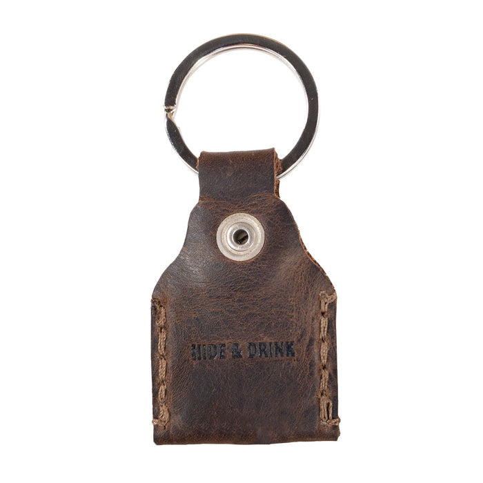 Reverse side of Hide & Drink Key Holder displaying the brand logo, emphasizing quality craftsmanship in Full Grain Leather. This Key Holder makes a practical Keychain Organizer and an essential emergency coin pouch. Handmade in La Antigua Guatemala & Oaxaca Mexico, showcasing the beauty of artisan craftsmanship in small batch production.