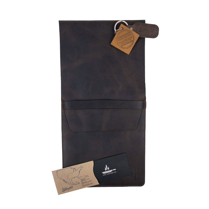 The Knife Case with 3 Slots by Cast Leather Co. displayed with care tags and the artisan's mark. This stylish knife organizer embodies rustic storage for kitchen utensils, crafted from full grain leather with a commitment to small batch production alongside hand-cut, hand-sewn techniques, fire branded for a unique touch, all handmade in La Antigua Guatemala & Oaxaca Mexico.