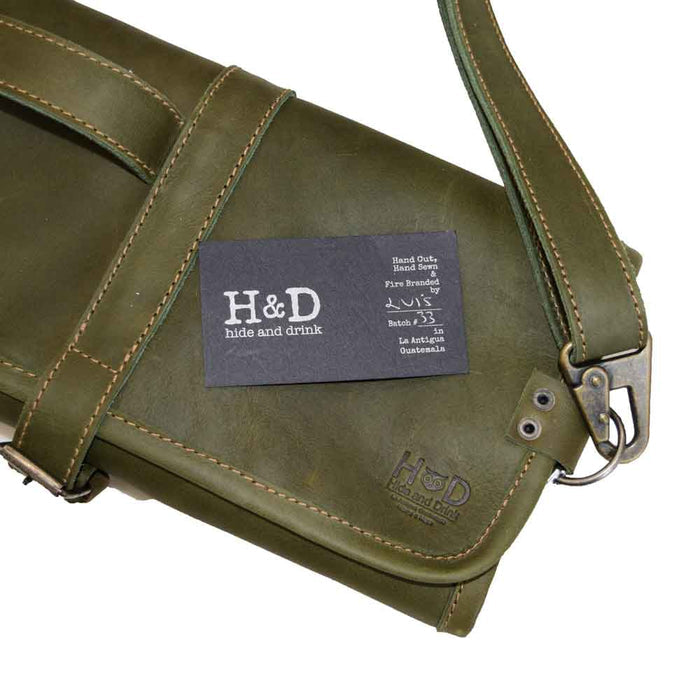 Close-up of the tag on Hide & Drink Knife Roll With Water Resistant Lining (8 Pockets) featuring full grain leather. Artisan-made Chef's Knife Roll Bag (8 Pockets) as a portable knife organizer for cooking accessories.