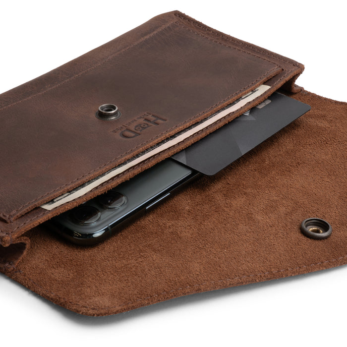An interior shot of the Large Female Wallet by Hide & Drink, which shows how it accommodates cash, cards, and a phone comfortably. This Vintage Money and Card Holder is an essential Travel Organizer for Women, crafted from Full Grain Leather through Small Batch Production and artisan methods, all Handmade in La Antigua Guatemala & Oaxaca Mexico.