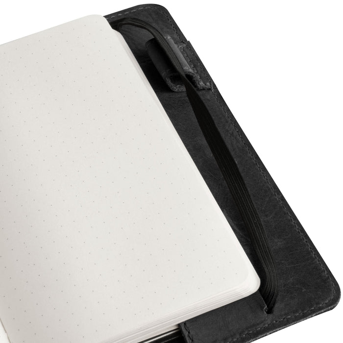 Close-up shot of the elastic band on Leuchtturm A6 Hardcover Case by Hide & Drink, emphasizing functionality and style. Ideal as a Leather A6 Notebook Cover for Leuchtturm 3.6 x 5.9 in. This case works well as a refillable mini planner case and travel journal cover for men; compatible with Moleskine & Hobonichi, and serves as a travelers pocket portfolio binder.