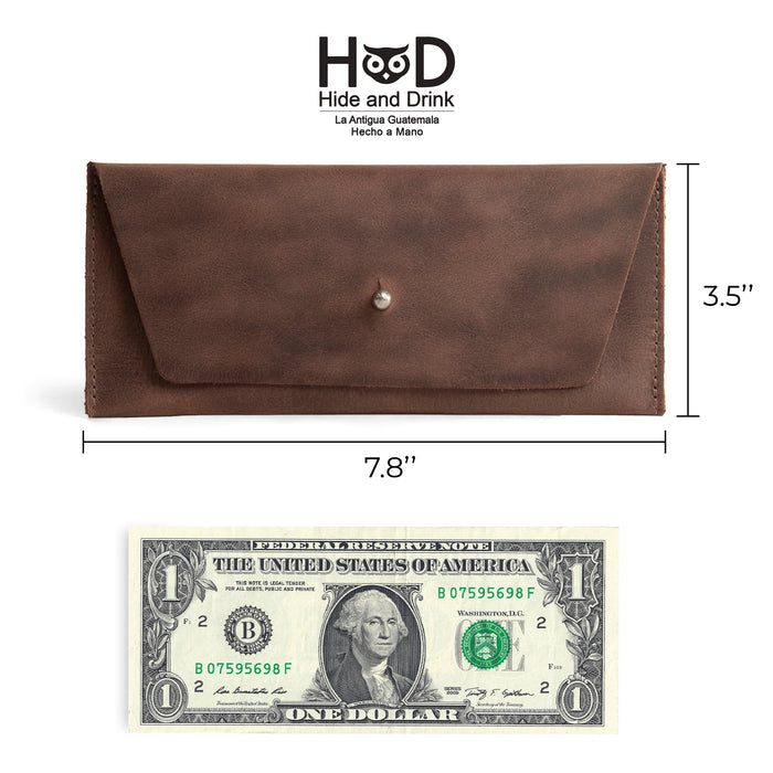 Dimensions of the Long Utility Pouch by Hide & Drink showcased next to a dollar bill for scale. This attractive handmade wallet is perfect for storing cash and cards while being an elegant accessory.