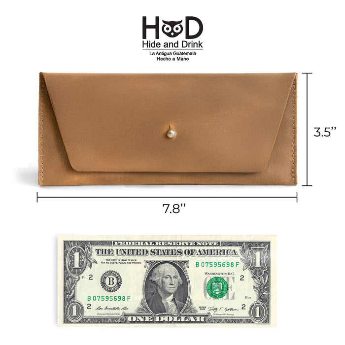 Dimensions of the navy blue Long Utility Pouch by Hide & Drink compared with a hundred dollar bill, showing its size and practicality as a wallet.