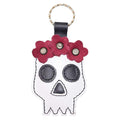 A beautifully handcrafted Mexican Skull Keychain by Hide & Drink, featuring intricate floral accents, perfect for Day Of The Dead celebrations. This unique piece showcases artisan craftsmanship with Full Grain Leather, making it a stylish accessory. Ideal for those who appreciate small batch production and handmade goods from La Antigua Guatemala & Oaxaca Mexico.
