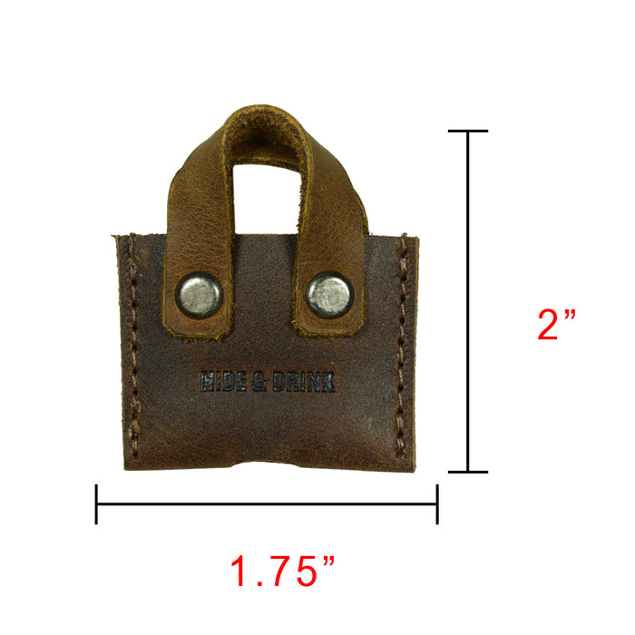 Hide & Drink's Mini Bags Key Cover (3 pack) features a detailed view of a brown mini bag key cover, perfectly sized and crafted from full grain leather. This keychain organizer is perfect for those who appreciate handmade quality, reflecting artisan practices from small batch production in La Antigua Guatemala & Oaxaca Mexico.