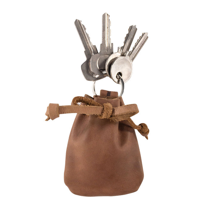 A Mini Medieval Pouch Keychain by Hide & Drink showcasing brown leather, ideal for carrying keys. This tiny bag with keyring is made from full grain leather, encapsulating the essence of a coin organizer with artisan craftsmanship from La Antigua Guatemala.